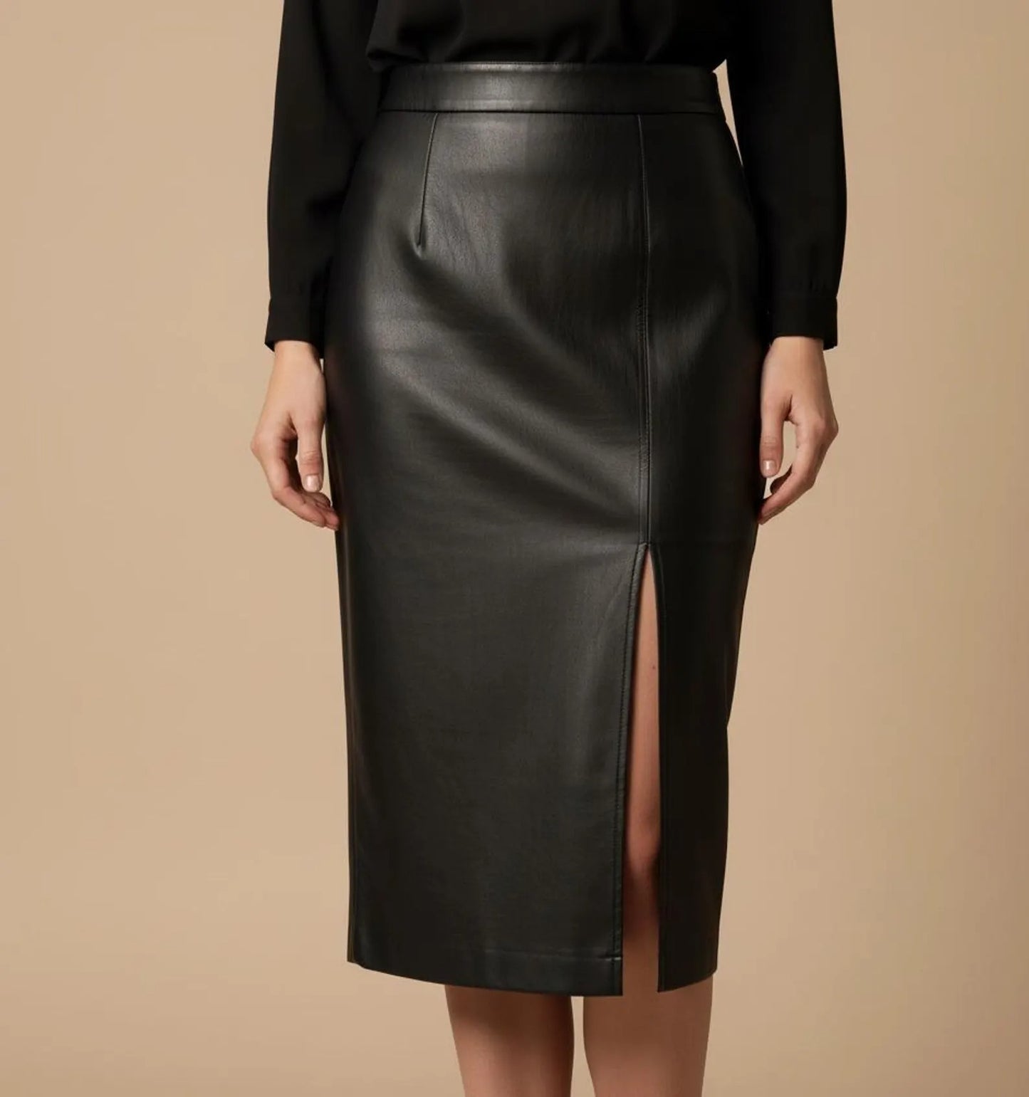 Black leather skirt worn by a person on a beige background
