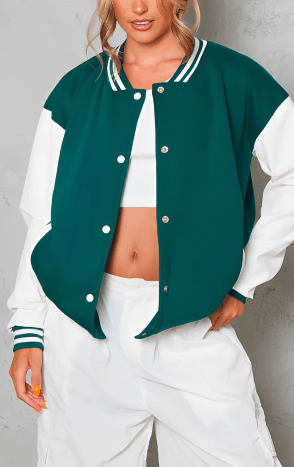 Person wearing a green and white varsity jacket over a white top and pants against a gray background