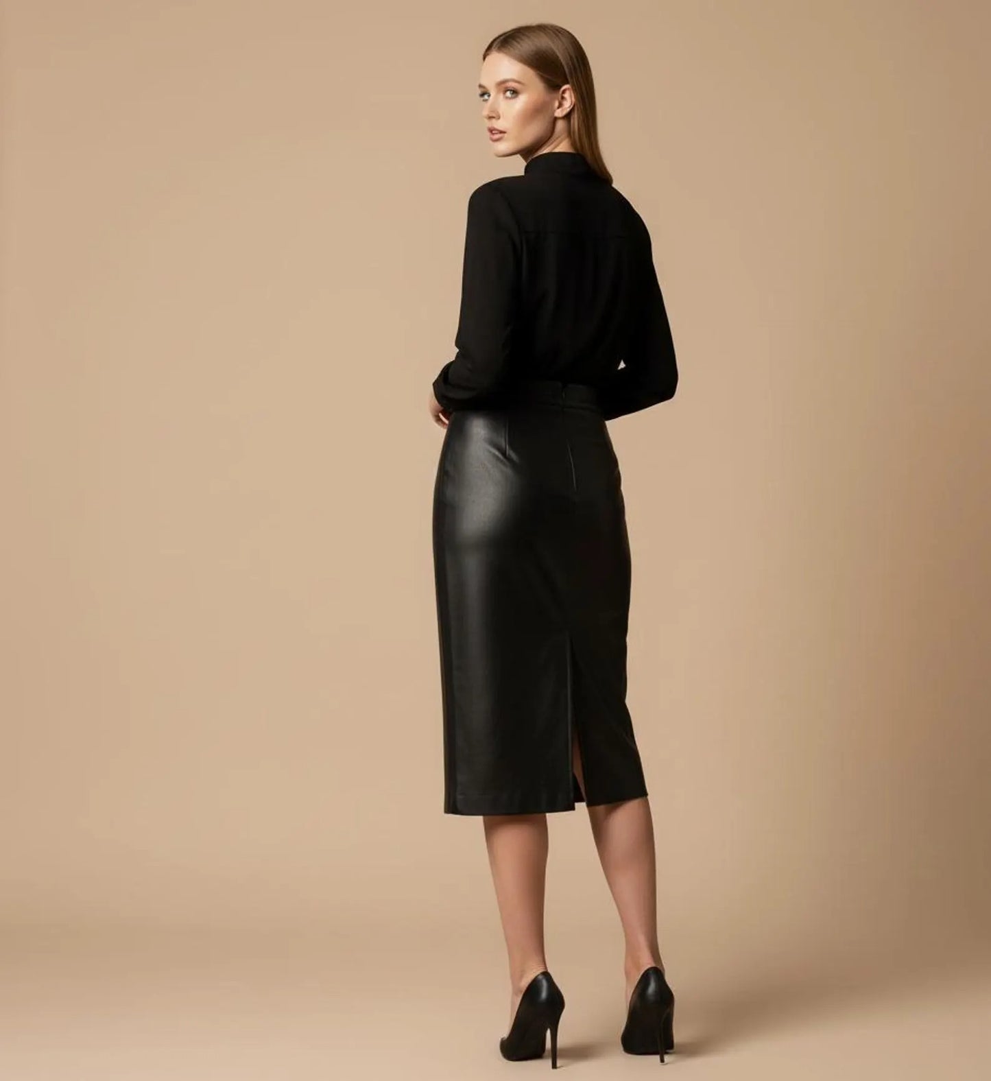 Woman wearing a black leather skirt and black top on a beige background