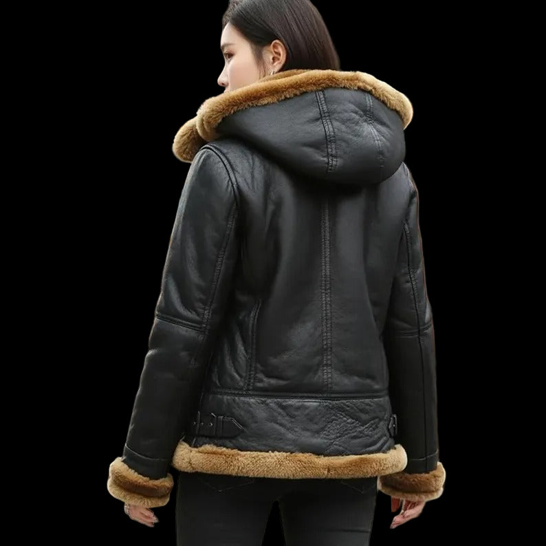 Person wearing a black leather jacket with fur trim in an urban setting