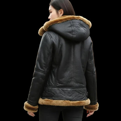 Person wearing a black leather jacket with fur trim in an urban setting