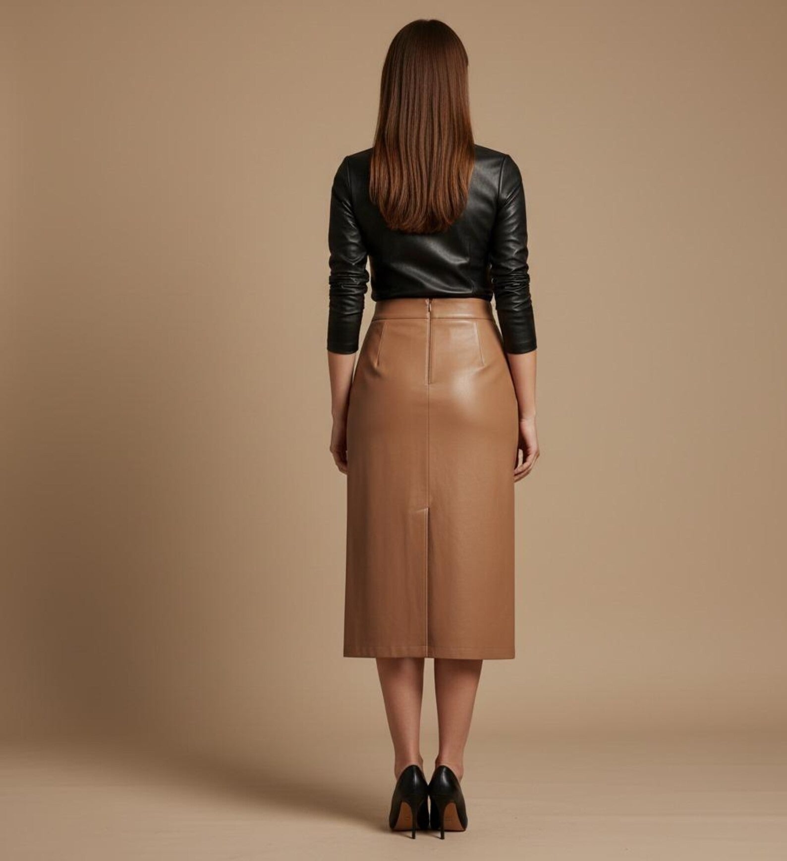 Woman wearing a brown leather skirt and tan leather skirt against a beige background