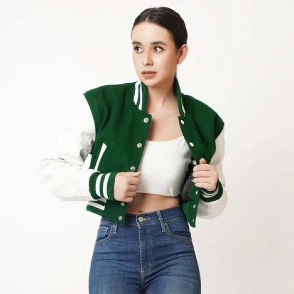 Woman wearing a green and white varsity jacket on a white background
