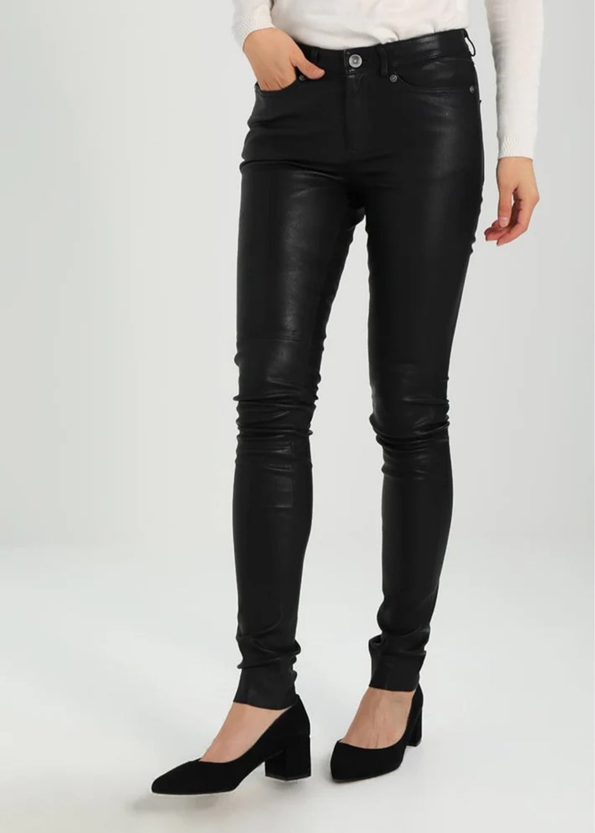 Black leather pants worn by a person on a white background