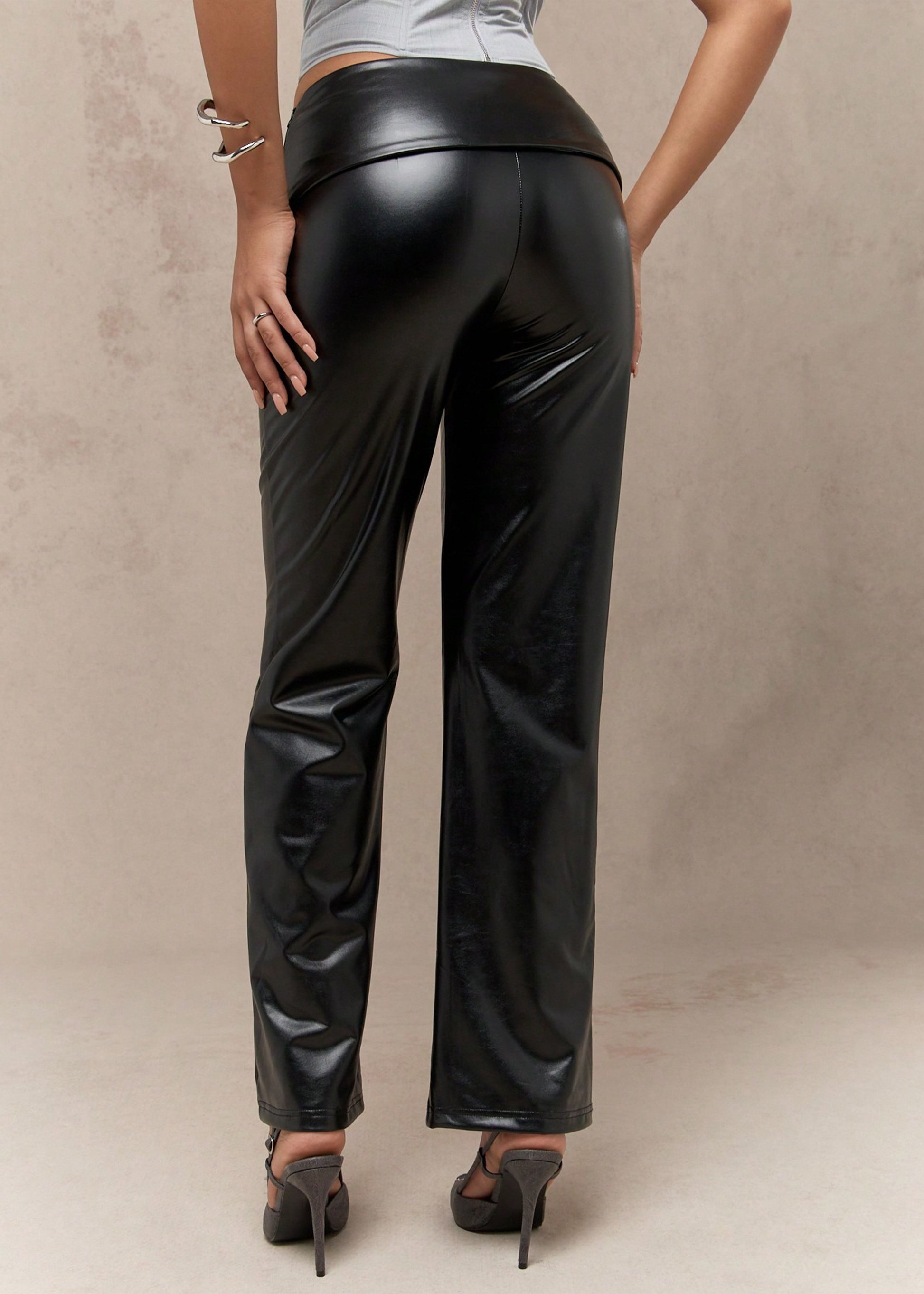 Black leather pants worn by a person on a neutral background