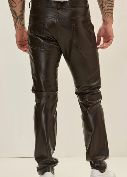 Person wearing black leather pants on a plain background
