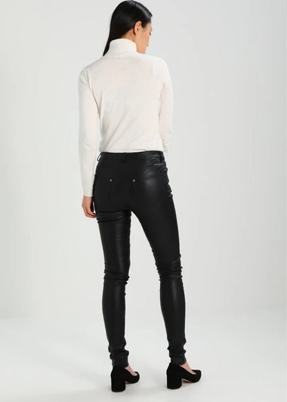 Person wearing black leather pants and a white turtleneck on a white background