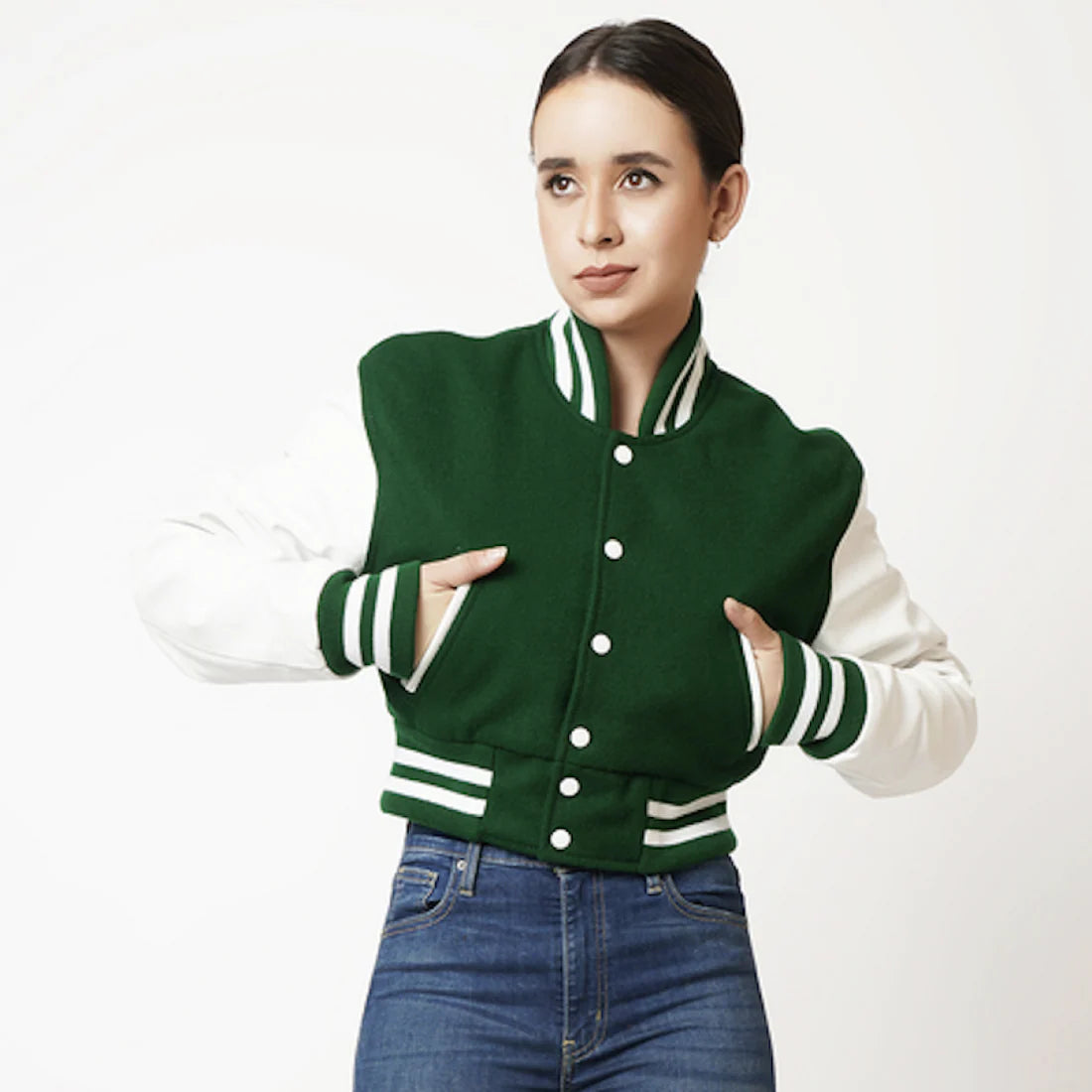 Woman wearing a green and white varsity jacket on a white background