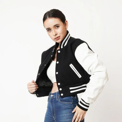 Person wearing a black and white varsity jacket on a white background
