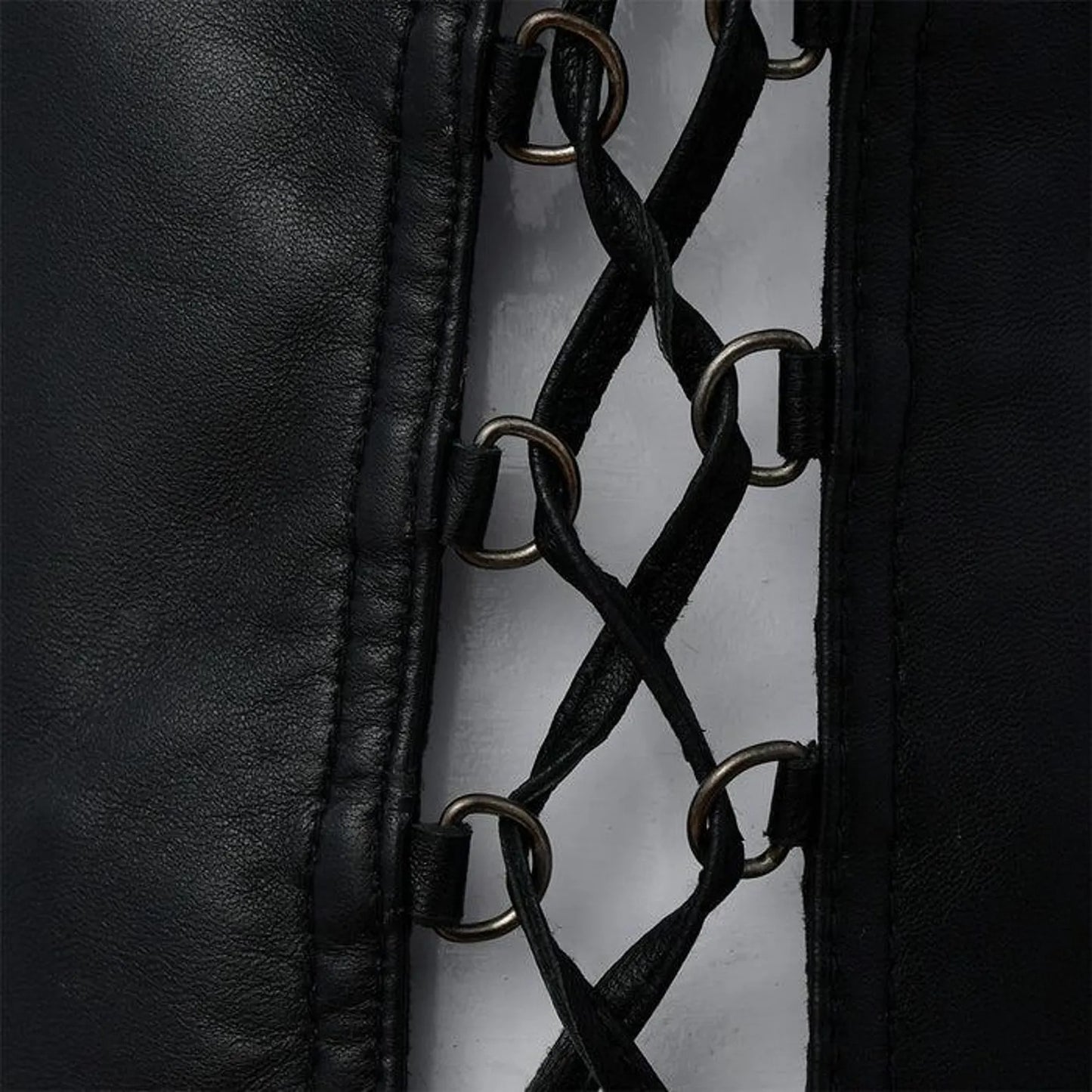 Close-up of black leather with metal rings and stitching