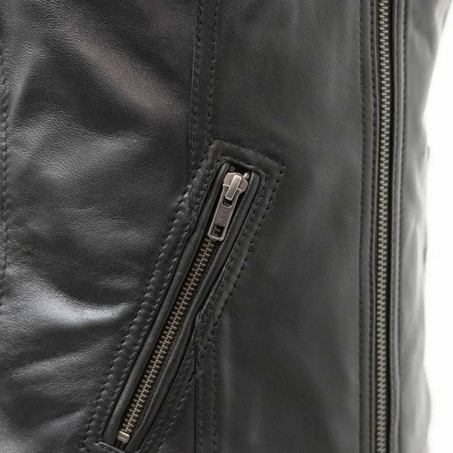 Close-up of a black leather jacket with a zipper detail on a white background