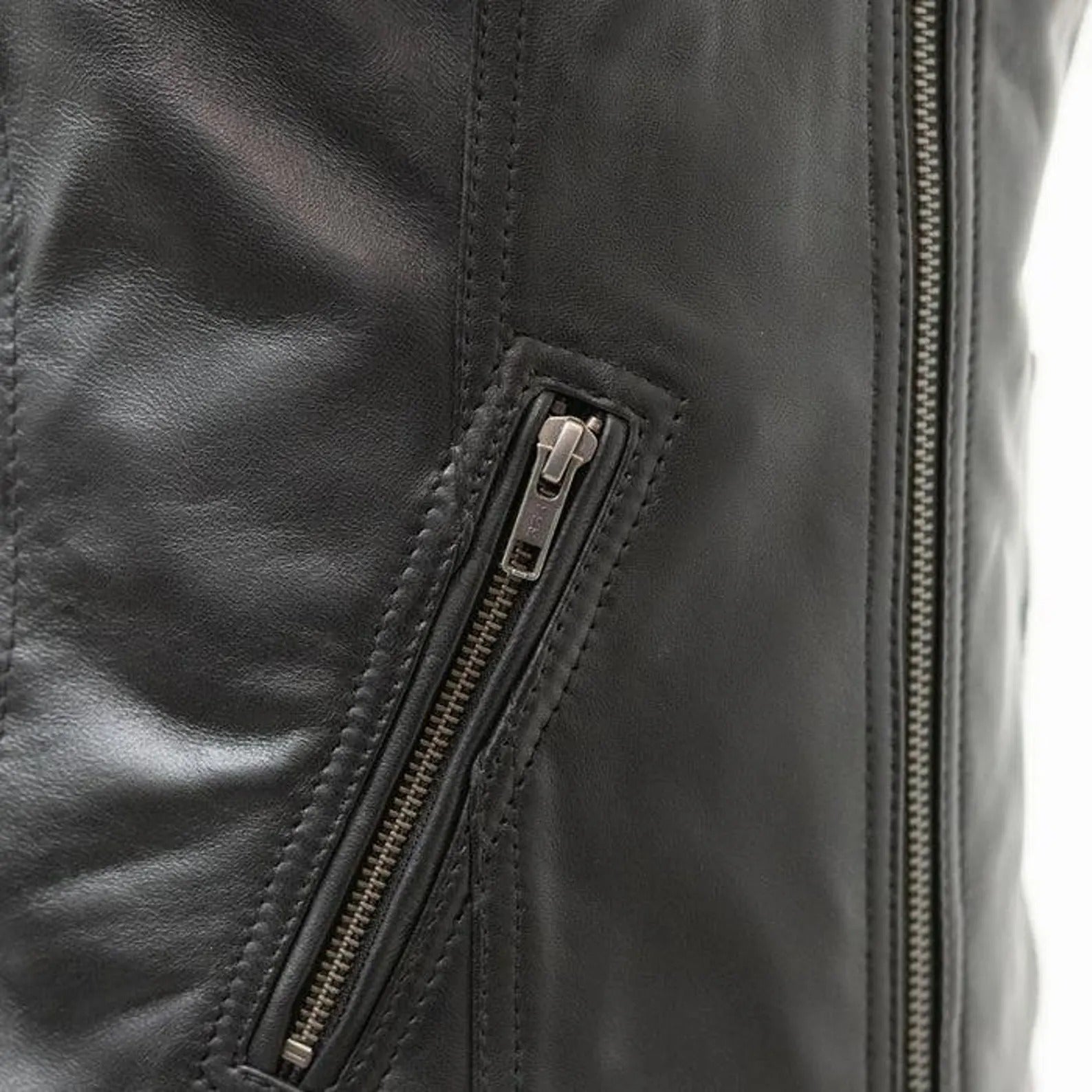 Close-up of a black leather jacket with a zipper detail on a white background